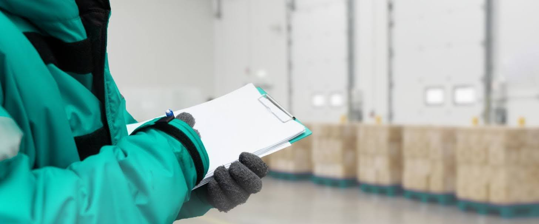 A person working in winter holding a clipboard.