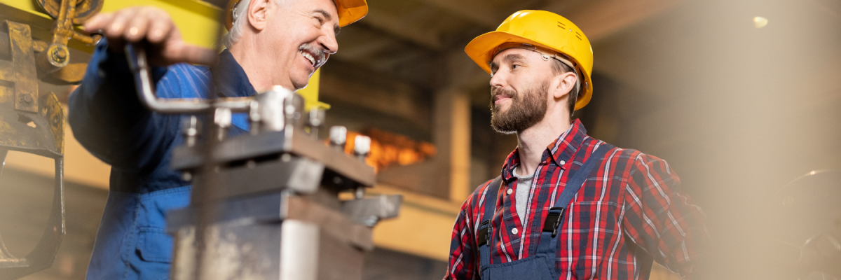 Two construction workers in protective equipment and hard hats