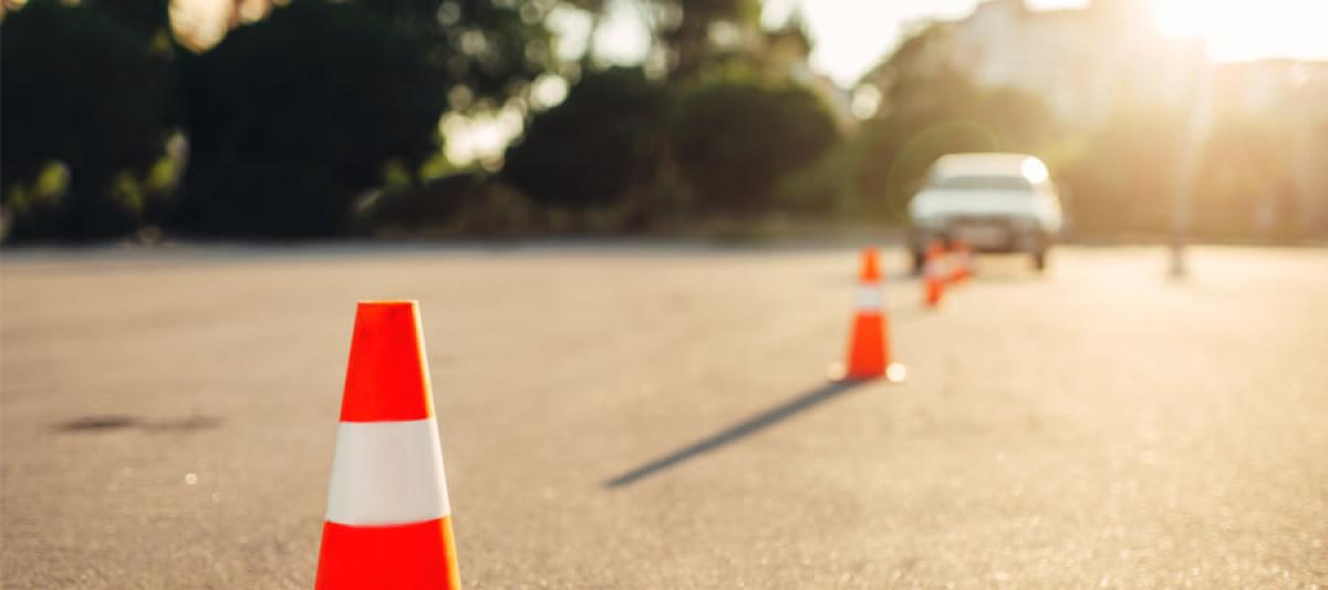 traffic cones in foreground with light and a car in background