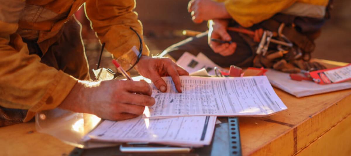 Miner signing off on permit or paperwork according to the mining safety requirements, from MSHA part 46 surface mine training or annual refresher